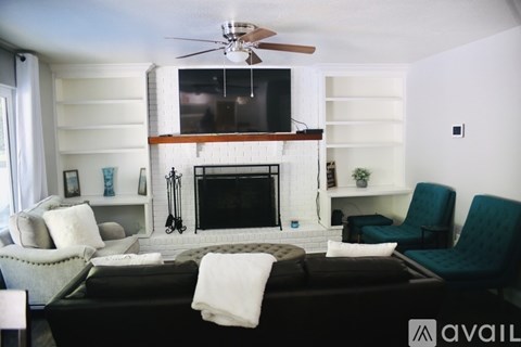 A living room with a fireplace and a television above it.