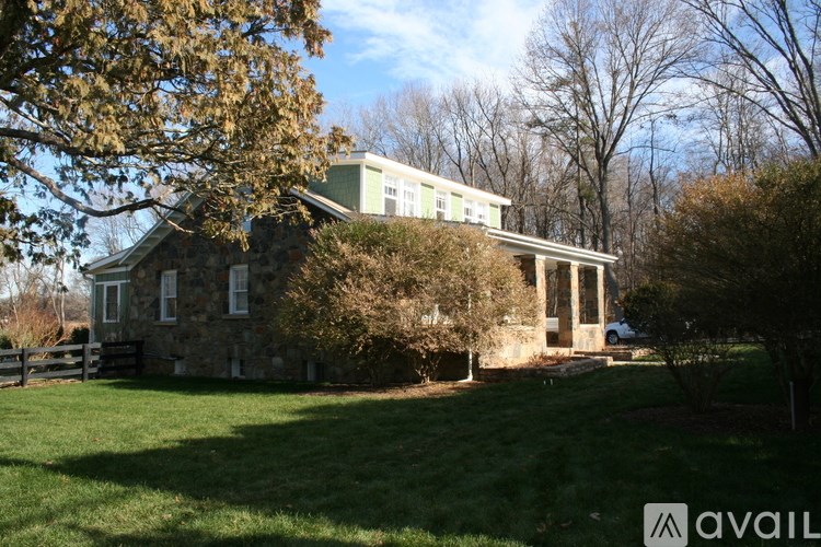 A house with a green lawn and trees in the background.