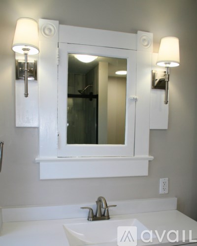 A bathroom with a white sink and a mirror above it.