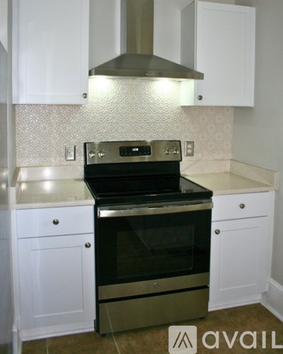 A kitchen with a black oven and white cabinets.