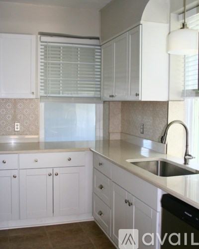 A kitchen with white cabinets and a sink.