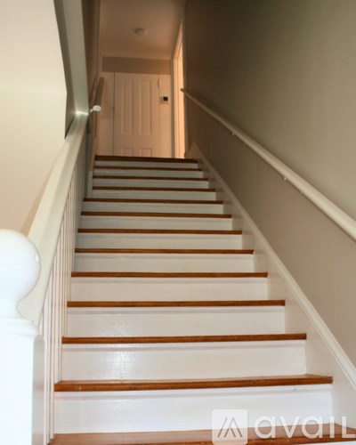 A staircase with white risers and wooden treads.