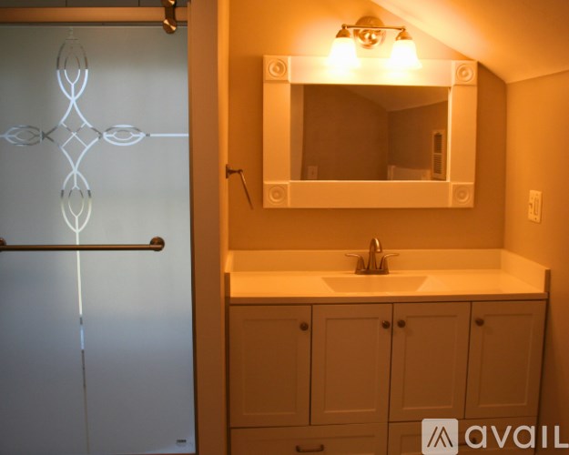 A bathroom with a sink, mirror, and cabinets.