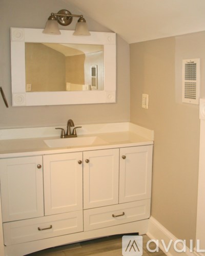 A bathroom with a white sink and cabinets.