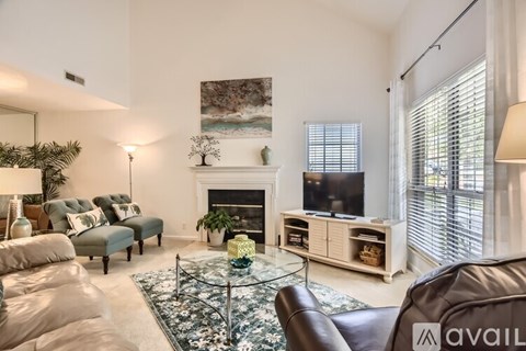 A living room with a fireplace and a painting on the wall.