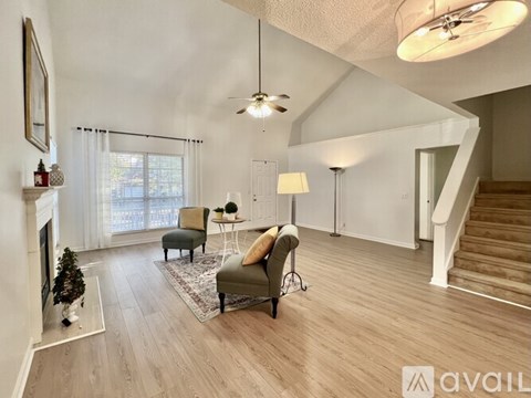 A bedroom with a bed, a dresser, a chair, and a ceiling fan.