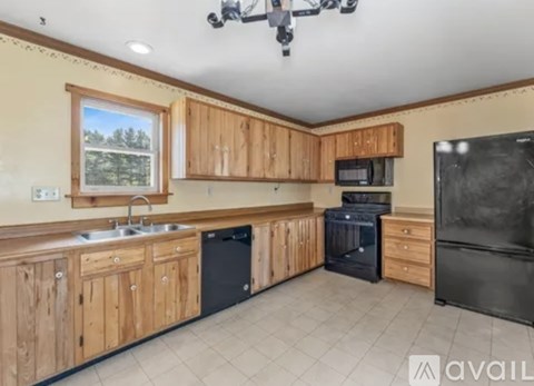A kitchen with wooden cabinets and black appliances.