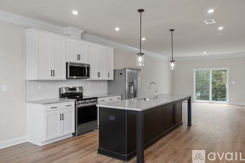 A modern kitchen with white cabinets and a black island.