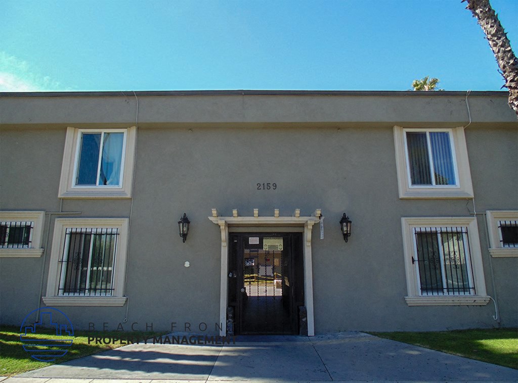 the front of a white building with a black door