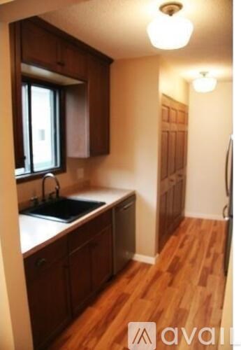 A kitchen with wooden cabinets and a black sink.