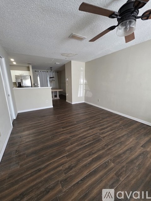 A room with wooden flooring and a ceiling fan.