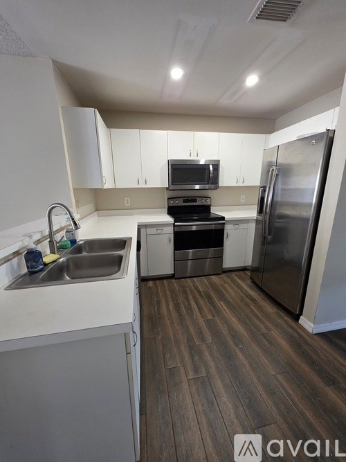 A kitchen with a sink, stove, and refrigerator.