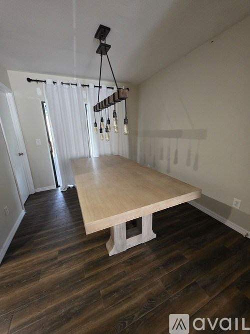 A room with a wooden table and a chandelier.