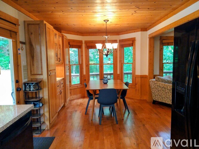 A kitchen with wooden floors and a dining table with chairs.
