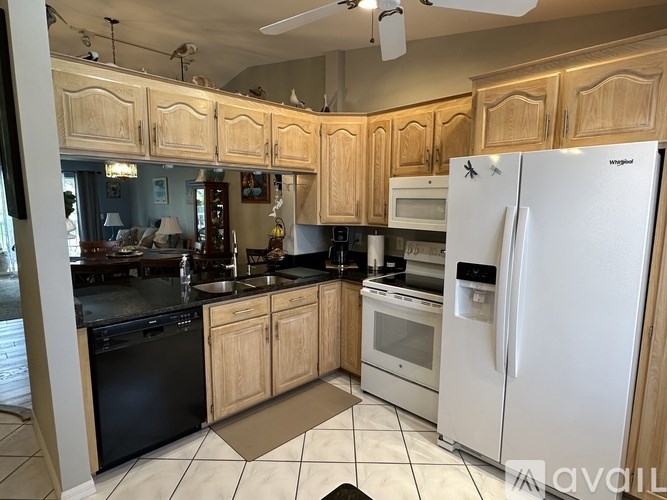 A kitchen with wooden cabinets and white appliances.