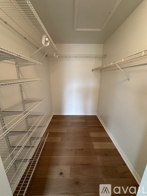 A cluttered walk-in closet with clothes and shoes.