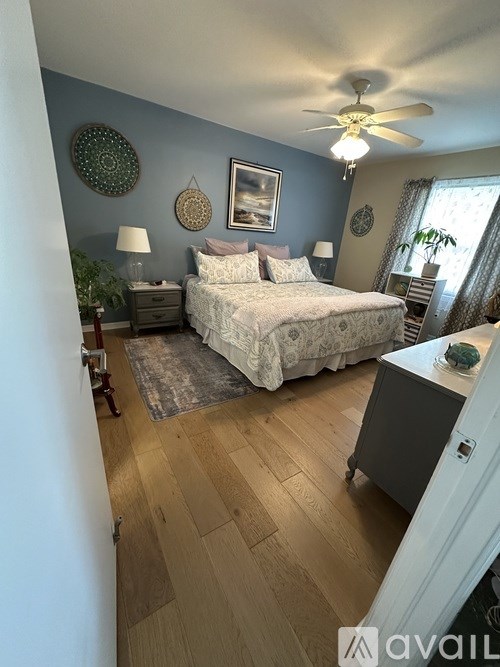 A bedroom with a bed, nightstand, and a ceiling fan.