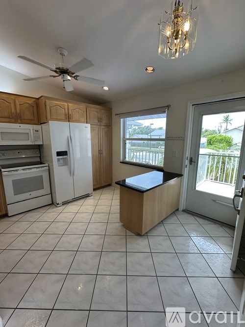 A kitchen with black chairs and a granite counter top.