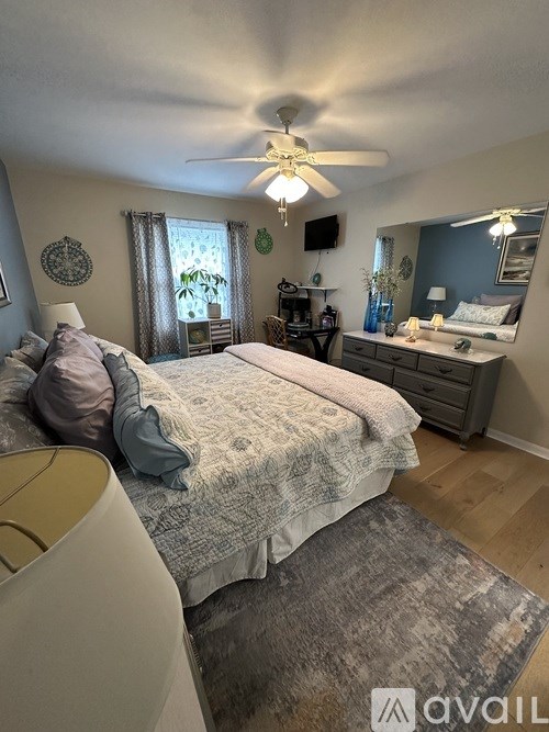 A bedroom with a large bed and a ceiling fan.