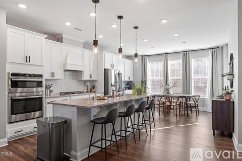 A modern kitchen with a large island and bar stools.