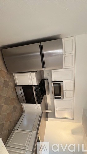 A kitchen with a stainless steel refrigerator and microwave.