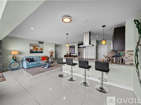 A modern kitchen with a bar area and a living room.