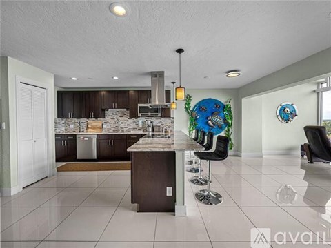A modern kitchen with a bar area and two chairs.