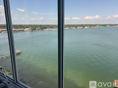 A view from a window looking out at a body of water and a dock.