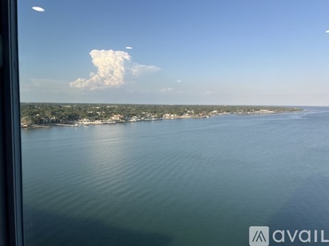 A large cloud is visible in the sky above a coastal landscape.