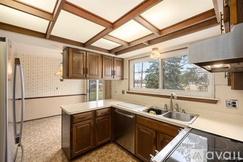 A kitchen with wooden cabinets and a refrigerator.