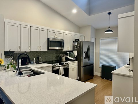 A kitchen with white cabinets and a white countertop.