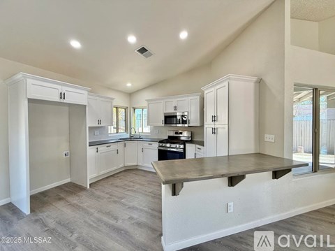 A spacious kitchen with white cabinets and a central island.