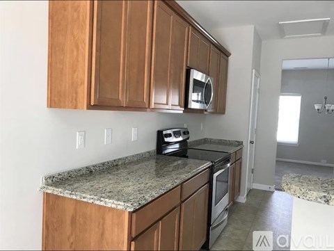 A kitchen with wooden cabinets and granite countertops.