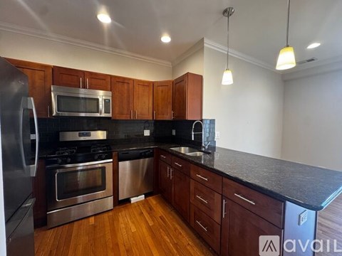 A kitchen with wooden cabinets and black countertops.
