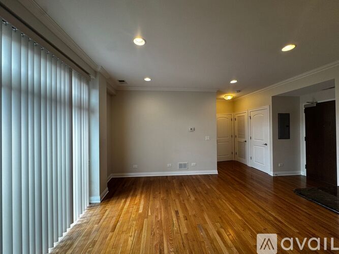 A spacious room with wooden floors and white walls.