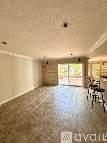 A room with a tiled floor and a bar stool.