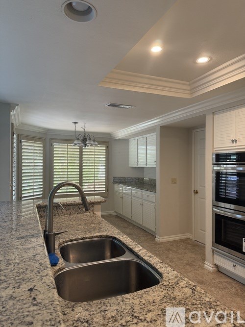 A room with white walls and a carpeted floor with a window on the left side.