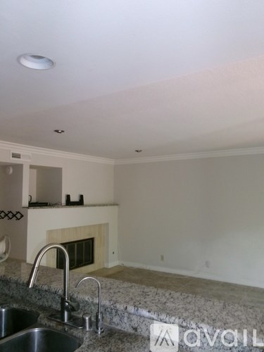 A room with a window covered by white blinds.