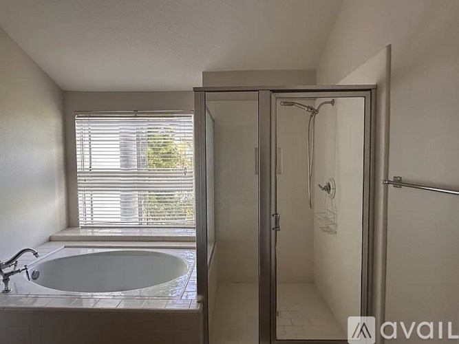 A bathroom with a white tub and a glass shower door.