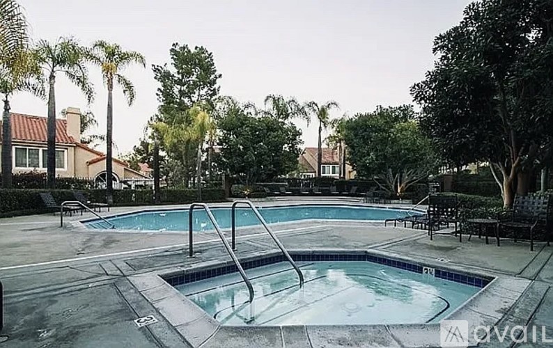 A pool surrounded by trees and a house.