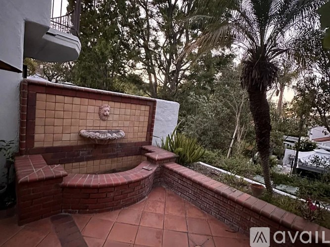 A red tiled outdoor shower with a bench seat.