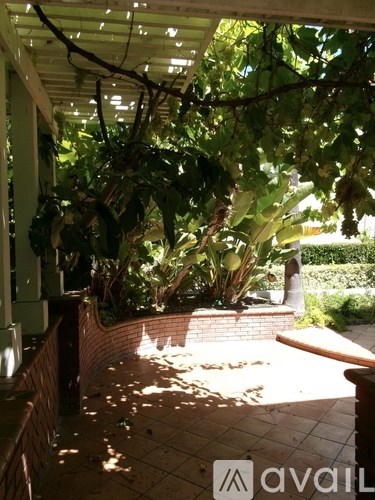 A patio area with a brick wall and a bench.