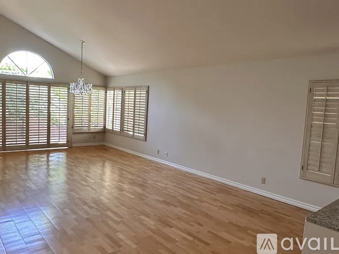 A room with wooden floors and a chandelier.