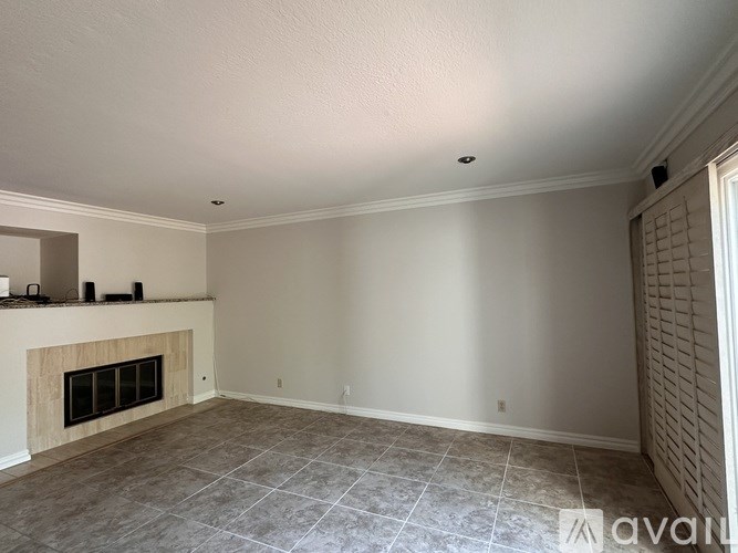 A living room with a fireplace and tiled flooring.