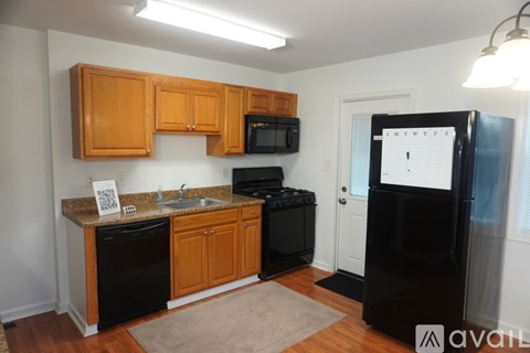 A kitchen with wooden cabinets and black appliances.