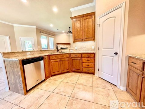 A kitchen with wooden cabinets and a tile floor.