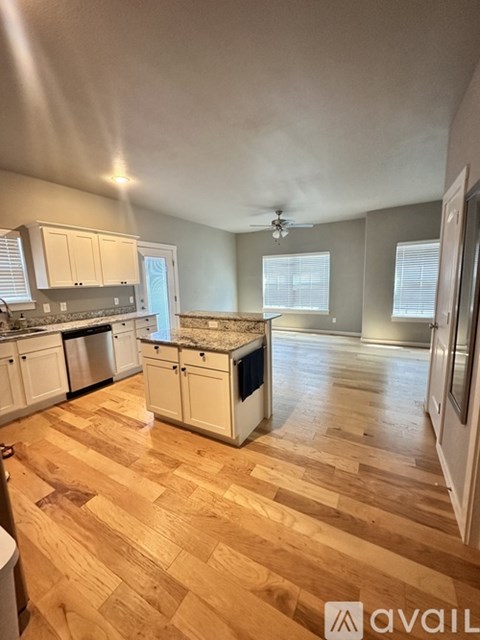 A kitchen with wooden floors and white cabinets.