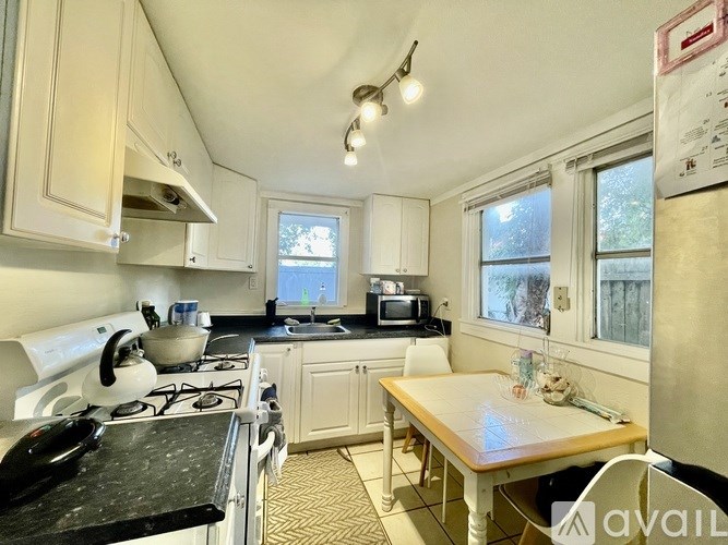 A kitchen with a stove, sink, and window.