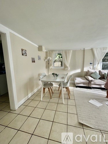 A living room with a white couch, a white chair, and a white table.