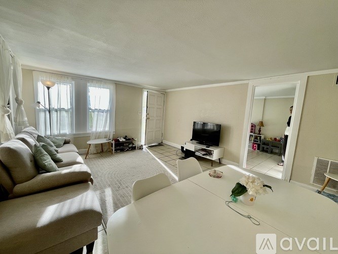 A living room with a white couch and a television.